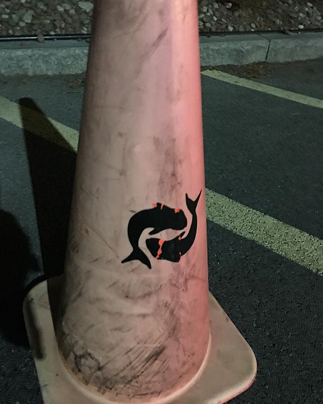 A road cone with koi painted on it